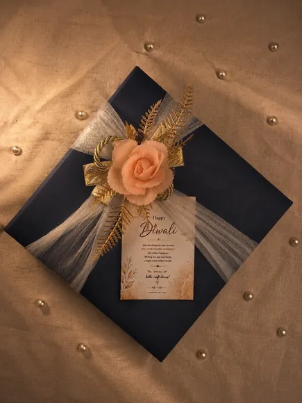 Navy gift box with a peach rose, golden leaves and a Diwali card